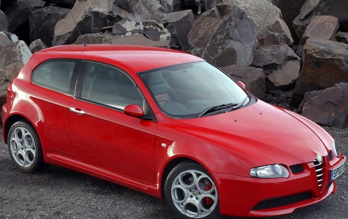 Alfa Romeo 147 GTA rojo aparcado delante un fondo natural en vista 3/4