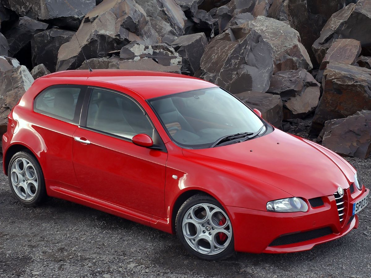 Alfa Romeo 147 GTA rojo aparcado delante un fondo natural en vista 3/4
